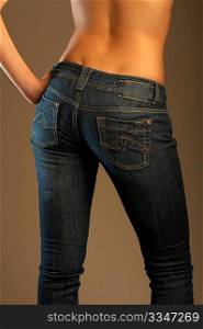 The bottom part of a female body dressed in jeans and turned by back