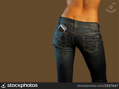 The bottom part of the girl in jeans with cellphone in a pocket