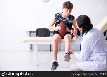 The boy american football player visiting young doctor traumatologis. Boy american football player visiting young doctor traumatologis