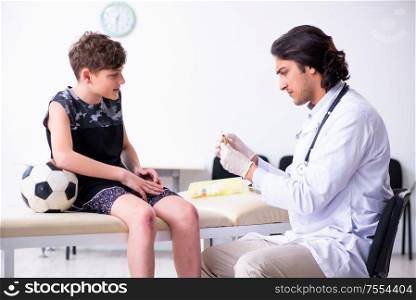 The boy football player visiting young doctor traumatologist. Boy football player visiting young doctor traumatologist