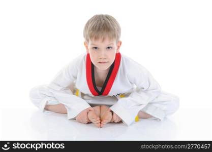 The boy in a kimono sits on a floor. isolated on a white background