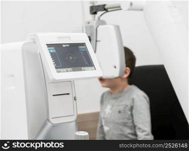 the boy is the patient on reception at doctor ophthalmologist. diagnostic ophthalmologic equipment. medicine concept. equipment in the eye clinic