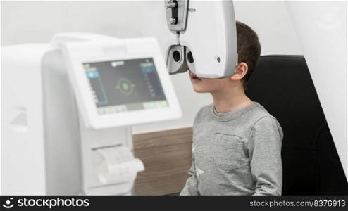 the boy is the patient on reception at doctor ophthalmologist. diagnostic ophthalmologic equipment. medicine concept. equipment in the eye clinic