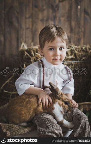 The boy plays with the animals in the manger.. Children and animals are friends 6050.