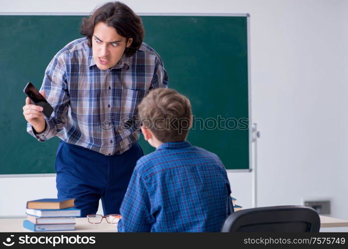 The boy using smartphone during the lesson. Boy using smartphone during the lesson