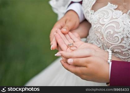 The bride and groom embrace each others palms.. Newlyweds hold wedding rings in their hands 2804.