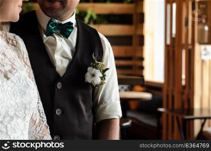 the bride and groom face each other on the background of wooden dining