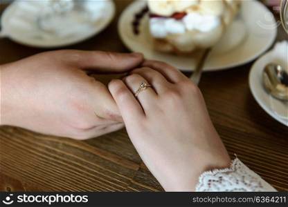 the bride and groom holding hands at a table in a cafe