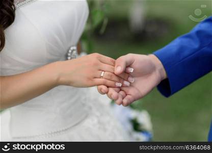 the bride and groom holding hands, wedding rings