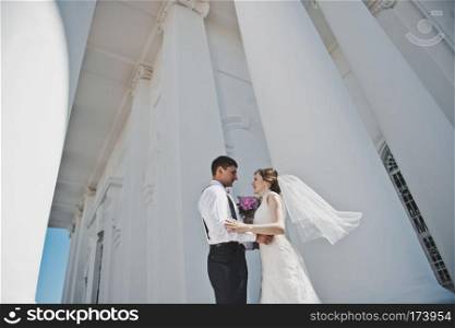 The bride and groom on the background of the white Church.. Newlyweds hugging on the background of the Church 3804.