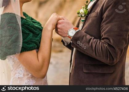 the bride and groom to hold hands, wedding rings