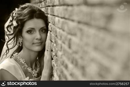 The bride at a wall. The young girl in a wedding dress.