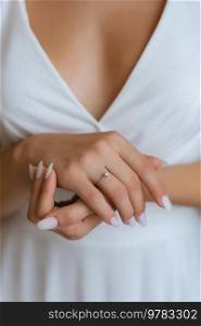 the bride gently touches her dear engagement ring