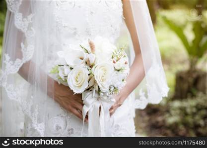 The bride holding flowers is entering to the wedding door in garden.Valentine?s Day.