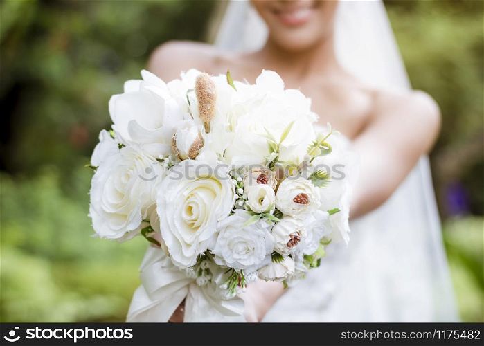 The bride holds a bouquet of flowers to prepare to throw for the bridesmaid.Valentine?s Day.