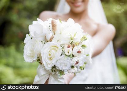 The bride holds a bouquet of flowers to prepare to throw for the bridesmaid.Valentine?s Day.