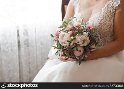 The bride in a bouquet in a chair.. A girl in a dress and with a bouquet is sitting in a chic armchair 3832.