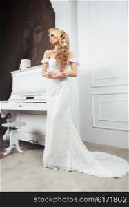 The bride in a long dress with a train. Long light hair. Wedding hairstyle.