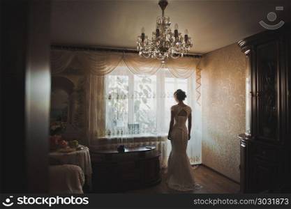 The bride in a wedding dress is by the window.. The bride about a light window 2303.. The bride about a light window 2303.