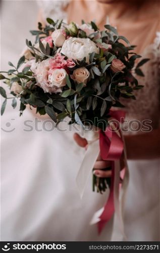 The bride in an openwork dress holds a necklace in her hands.. The process of equipping the bride before the wedding 3798.