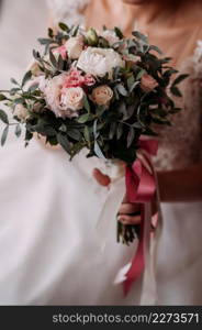 The bride in an openwork dress holds a necklace in her hands.. The process of equipping the bride before the wedding 3798.