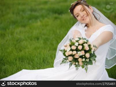 The bride on a lawn. The young girl in a wedding dress.