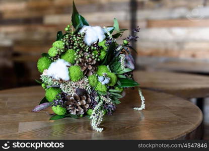 the bride&rsquo;s bouquet from cones and cotton close up in natural light on a wooden table