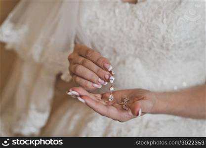 The bride shows the earrings holding them in the palms.. Female hands holding the weight of the beautiful decorations 502.
