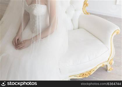 the bride sits on a vintage white chair