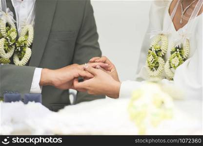 The bride wears a wedding ring on the groom on right hand ring finger on her wedding day