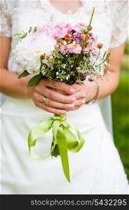 The bride with a wedding bouquet close up outdoor. Shallow deep of field