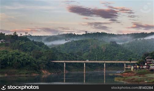 the bridge over the river in morning with fog and view of mist at Sangkhlaburi, Focus at the bridge 