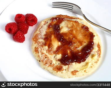 The British way of eating Scotch pancakes - spread with butter and raspberry jam.