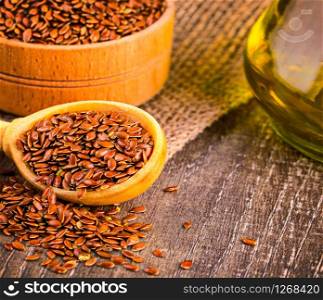 The Brown flax seeds and flaxseed oil on a wooden table