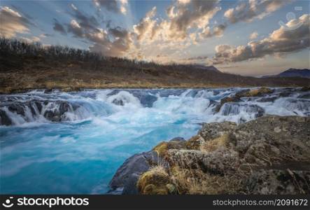 The Bruarfoss waterfall in South Iceland with a colorful sunset an blue water