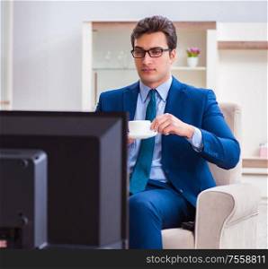 The businesman watching tv in office. Businesman watching tv in office
