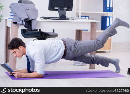 The businessman doing sports in office during break. Businessman doing sports in office during break