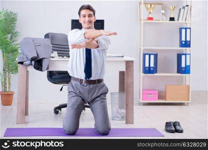 The businessman doing sports in office during break. Businessman doing sports in office during break