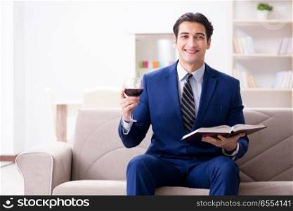The businessman drinking wine sitting at home. Businessman drinking wine sitting at home
