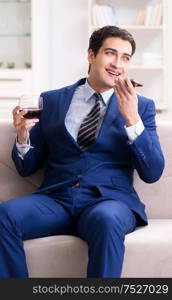 The businessman drinking wine sitting at home. Businessman drinking wine sitting at home