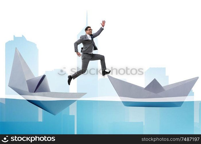 The businessman escaping sunken paper boat ship. Businessman escaping sunken paper boat ship