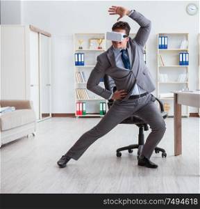 The businessman exercising in office wearing vr glasses. Businessman exercising in office wearing VR glasses