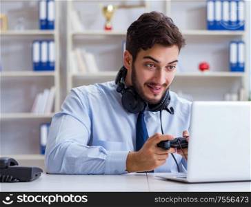The businessman gamer in office playing games. Businessman gamer in office playing games