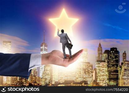 The businessman held on hand reaching out for stars. Businessman held on hand reaching out for stars
