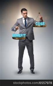 The businessman in cost benefit balance concept. Businessman in cost benefit balance concept. The businessman in cost benefit balance concept