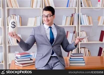 The businessman in library with a money sack and a laptop. Businessman in library with a money sack and a laptop