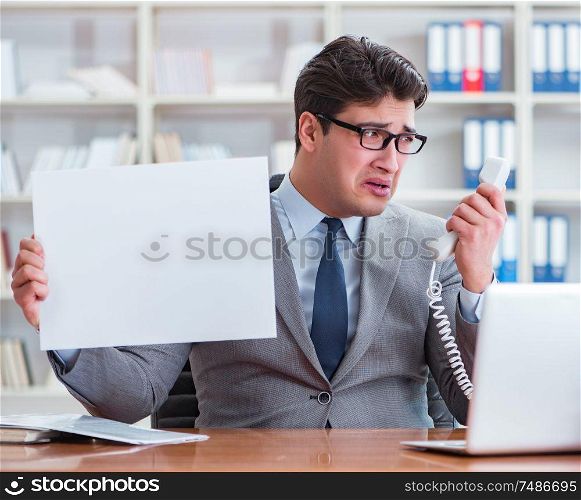 The businessman in office holding a blank message board. Businessman in office holding a blank message board