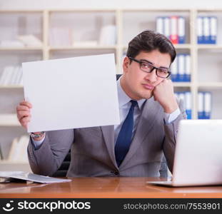 The businessman in office holding a blank message board. Businessman in office holding a blank message board