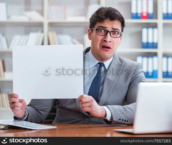 The businessman in office holding a blank message board. Businessman in office holding a blank message board