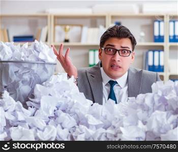 The businessman in paper recycling concept in office. Businessman in paper recycling concept in office